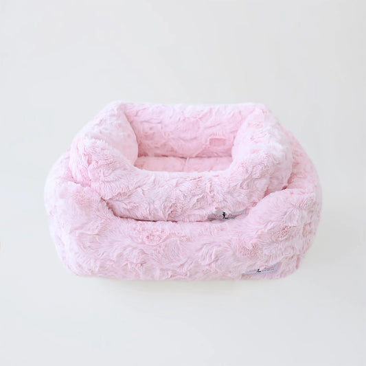 Pink textured pet bed on a white background