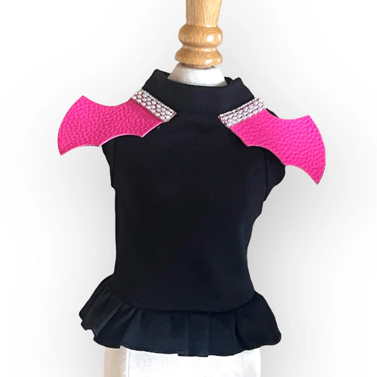 Black top with pink shoulder pads on a mannequin against a white background
