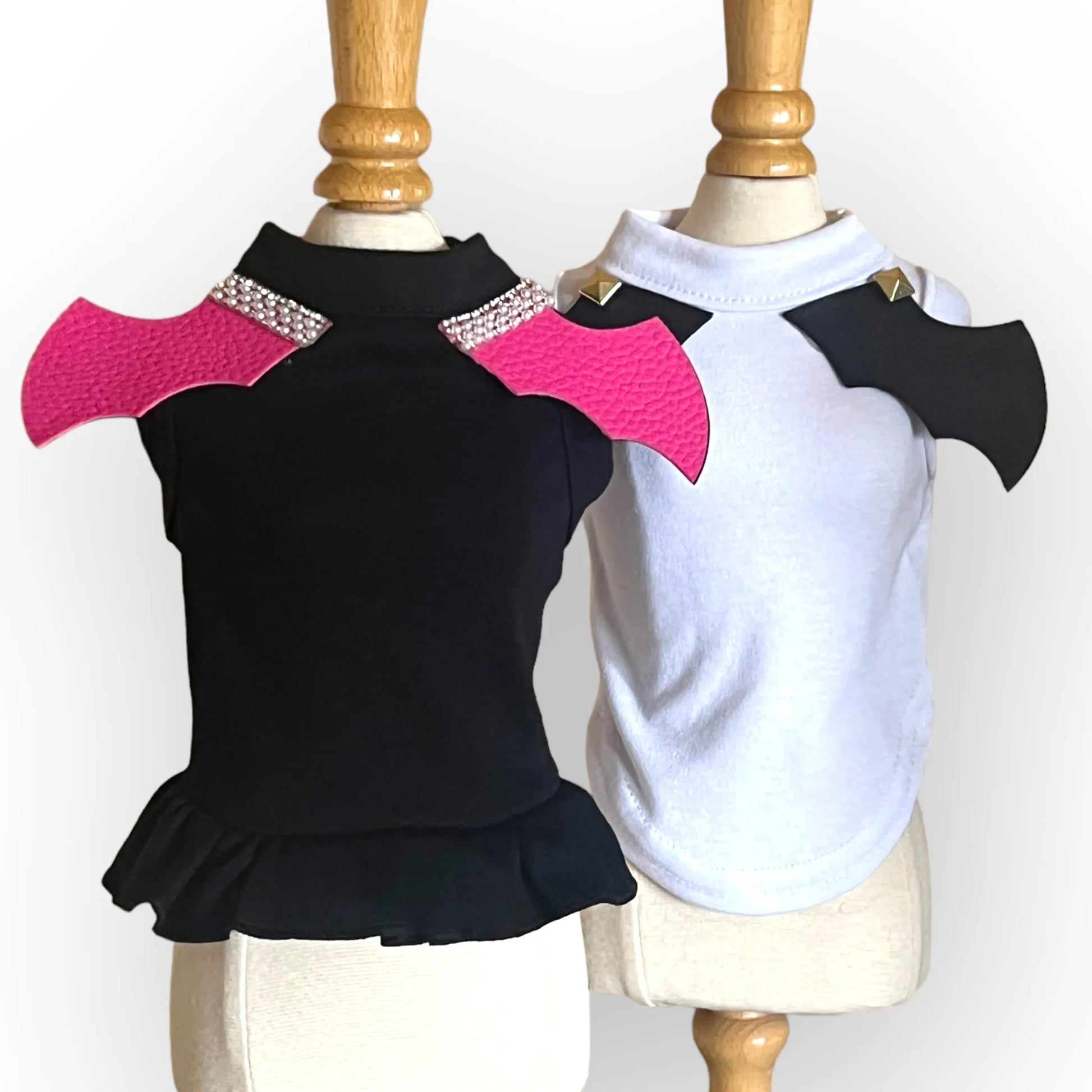 Black and white dog dresses with pink and black shoulder pads on mannequins.