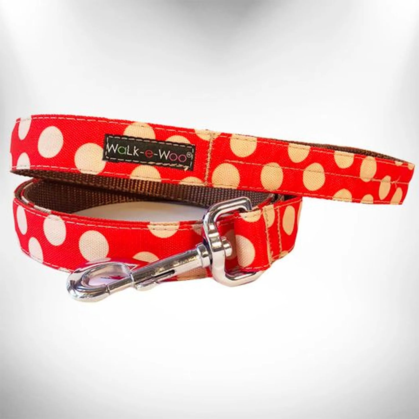Dog leash with red and beige polka dot pattern on a white background