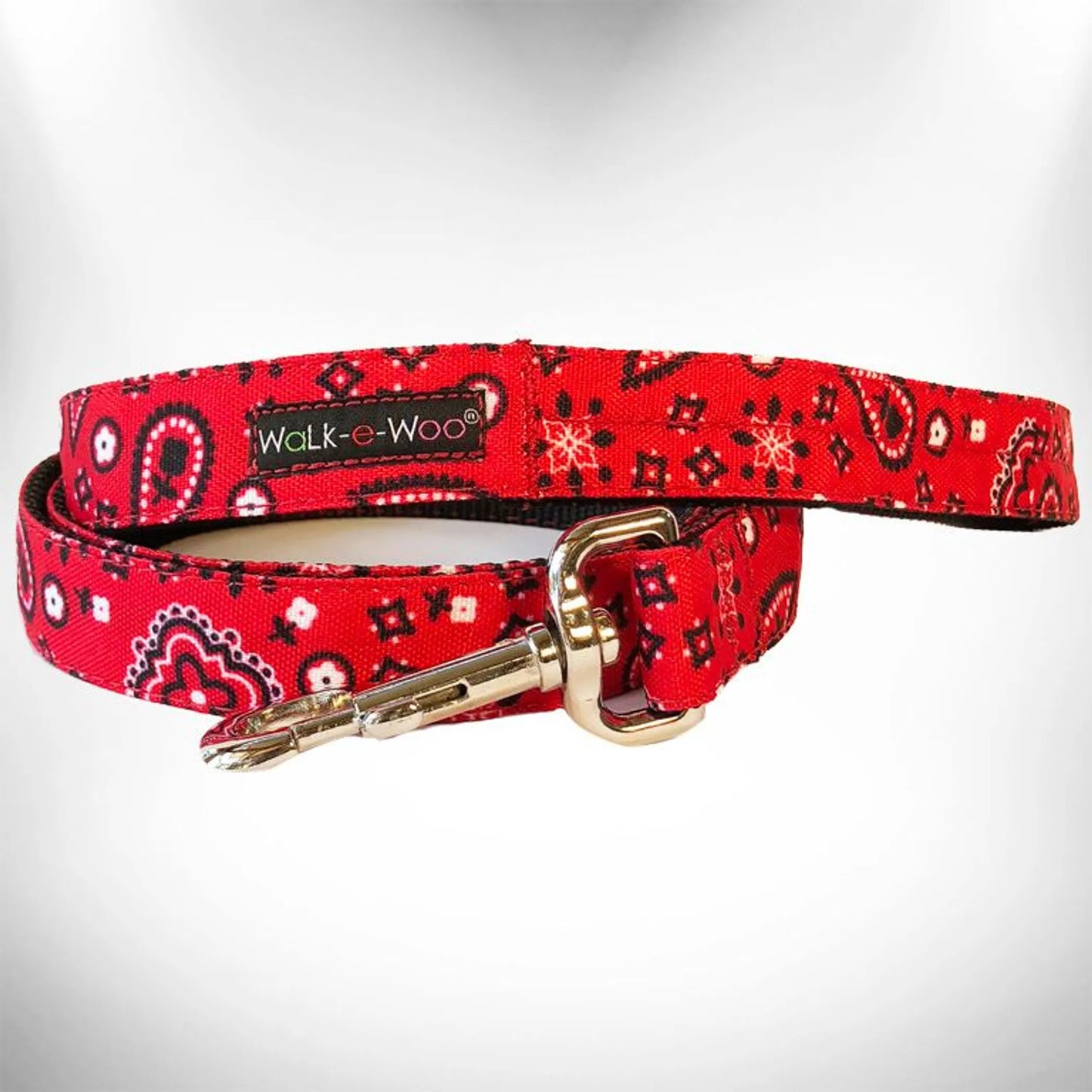 Red dog leash with bandana pattern and gold clasp on a white background
