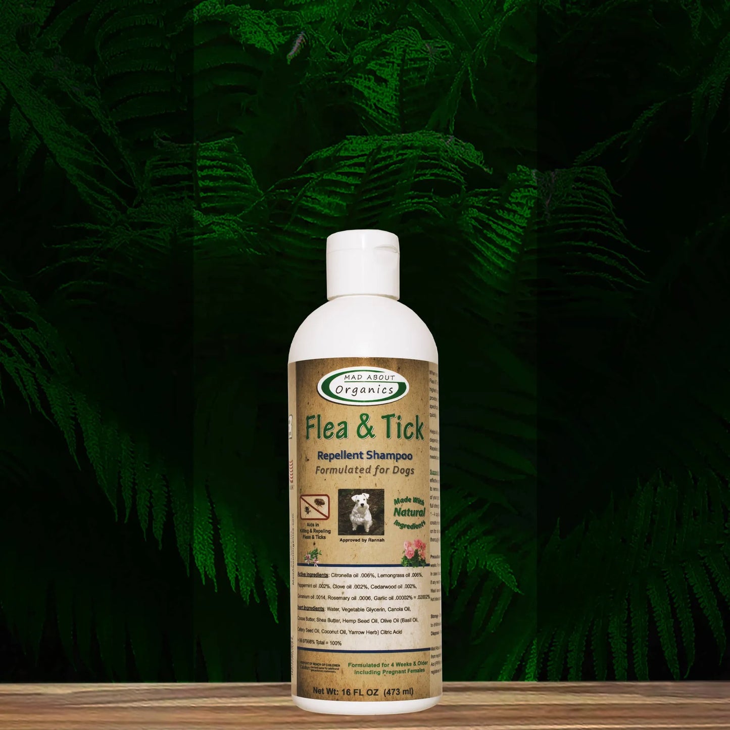 Flea and tick repellent shampoo bottle on a wooden surface with green foliage in the background