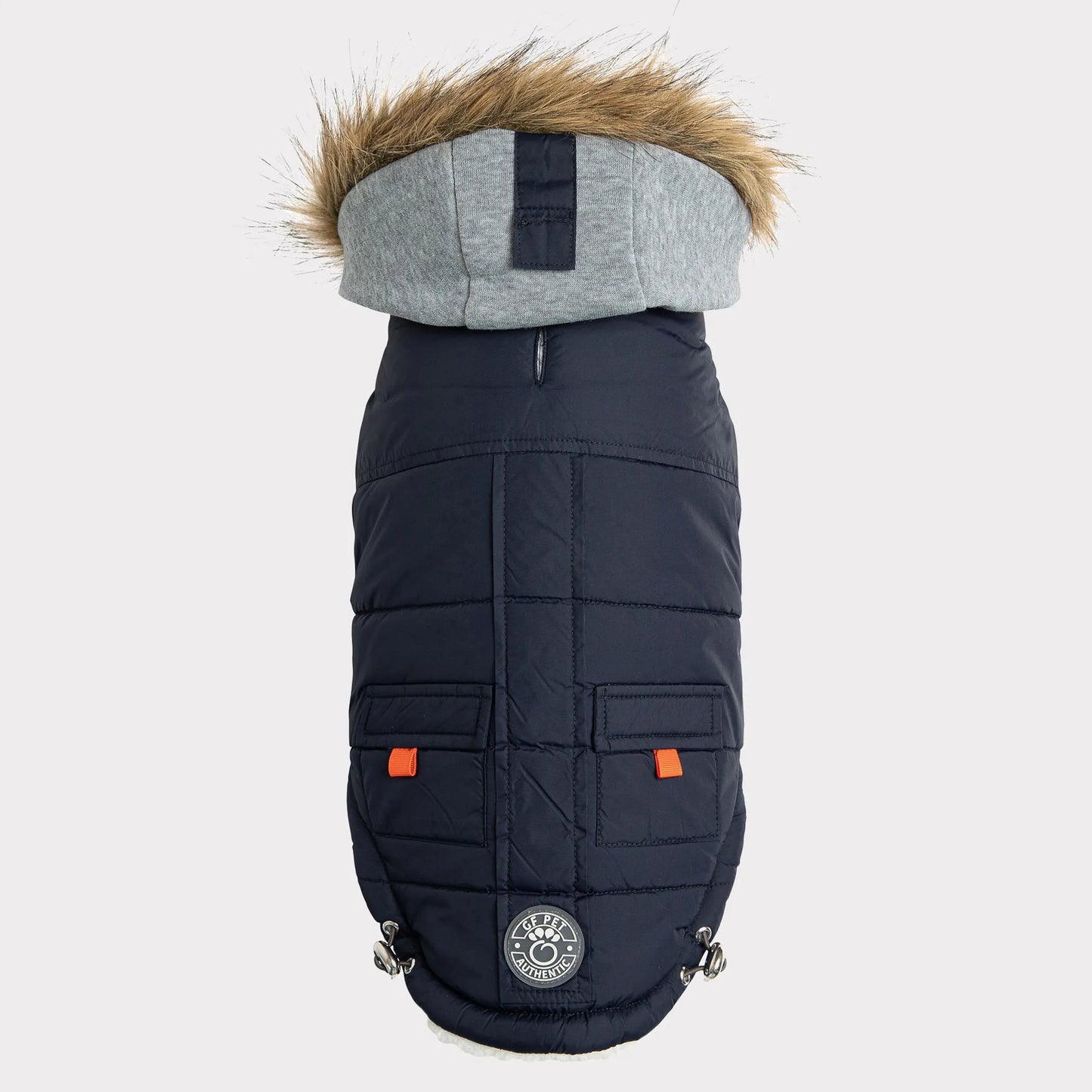 Navy blue quilted dog coat with gray hood and orange patches on a light gray background