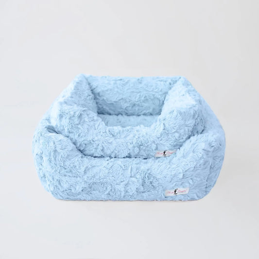 Blue fluffy pet bed on a light gray background