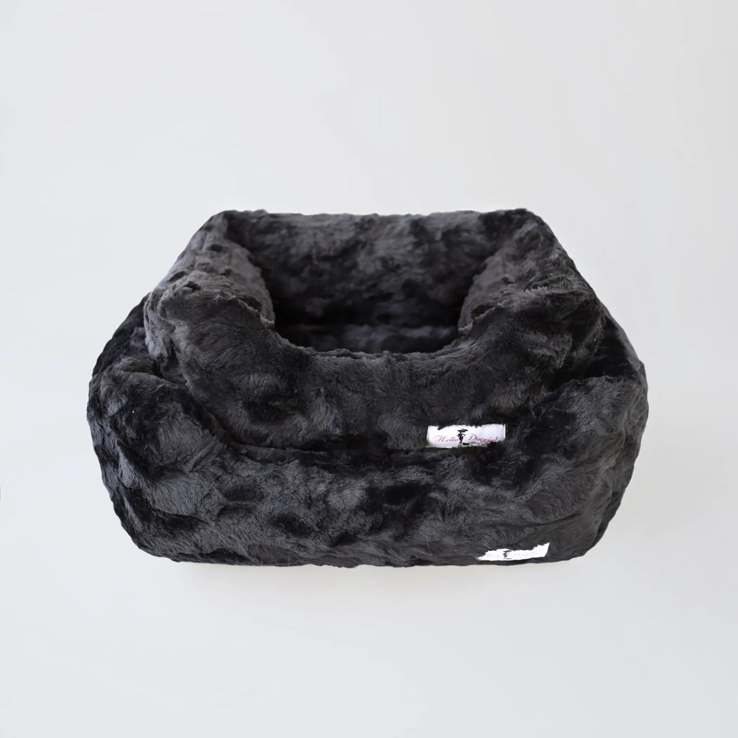 Black faux fur pet bed on a white background
