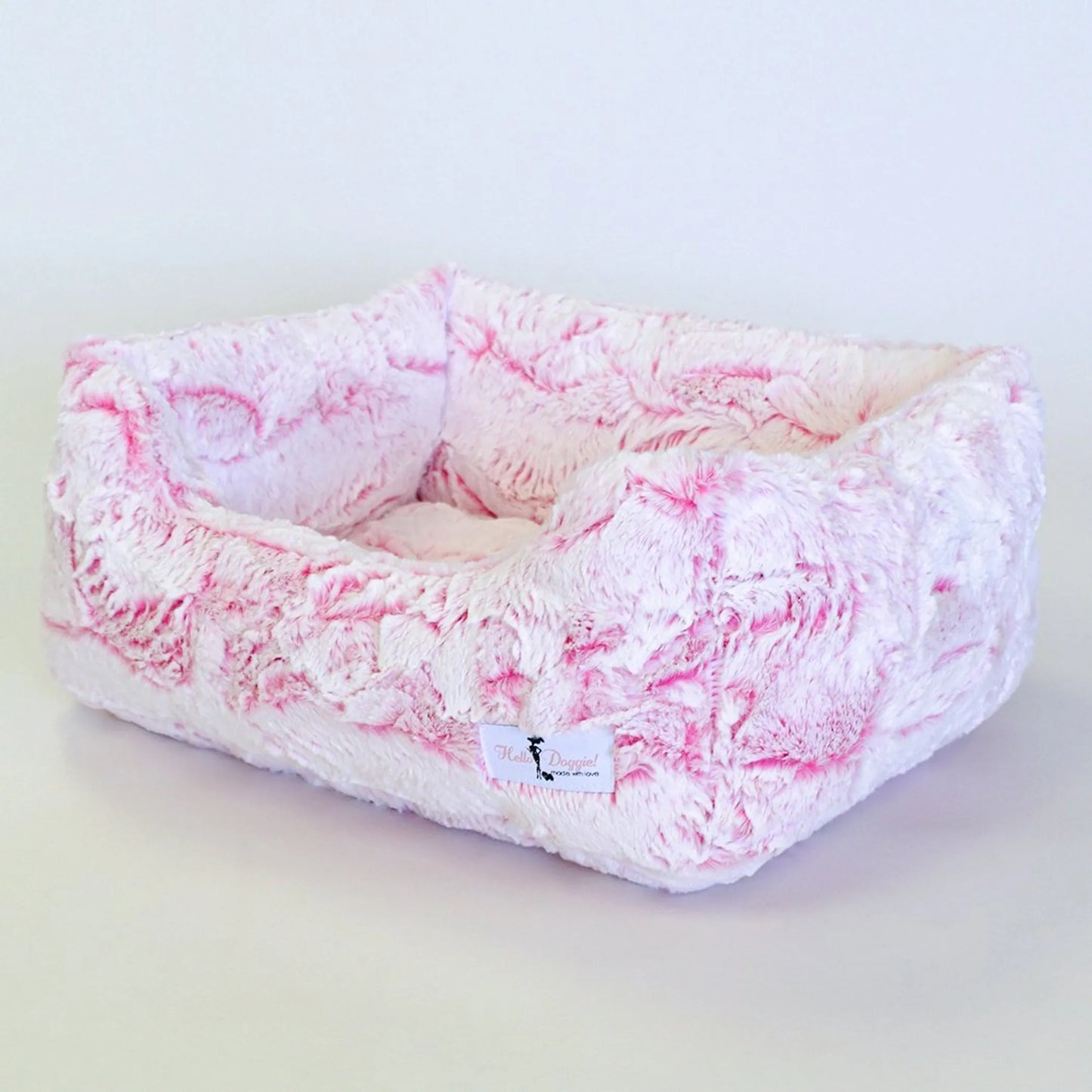 Pink and white marbled pet bed on a light gray background