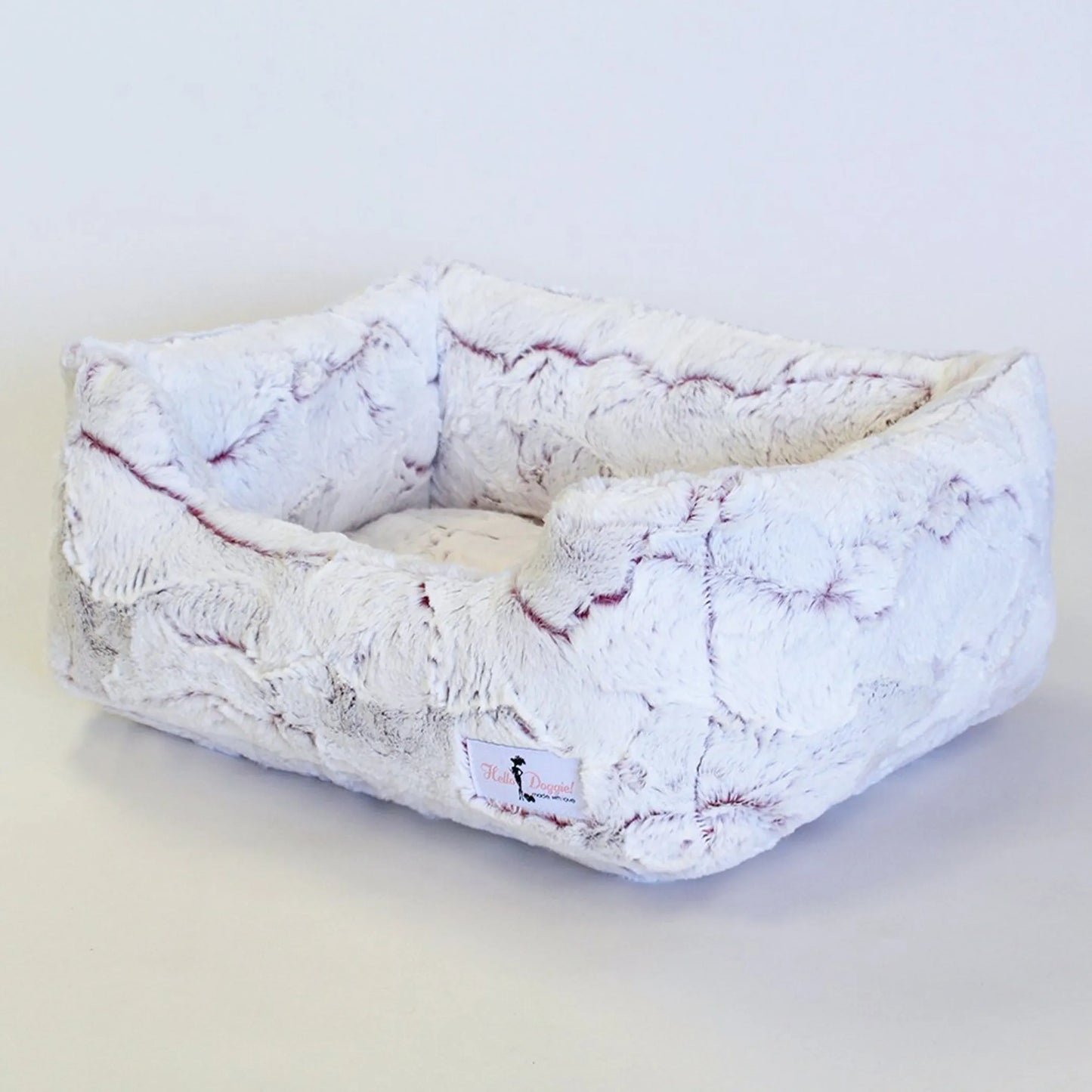 Fluffy pet bed with a white and gray pattern on a light background