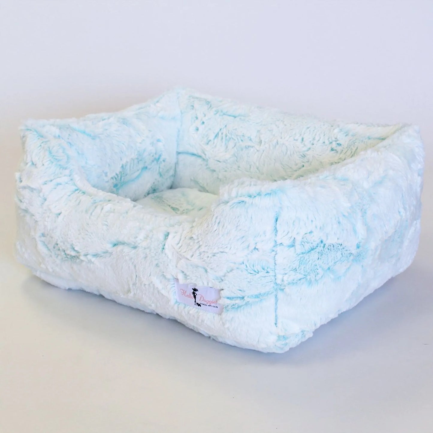 Fluffy pet bed with blue and white pattern on a light gray background